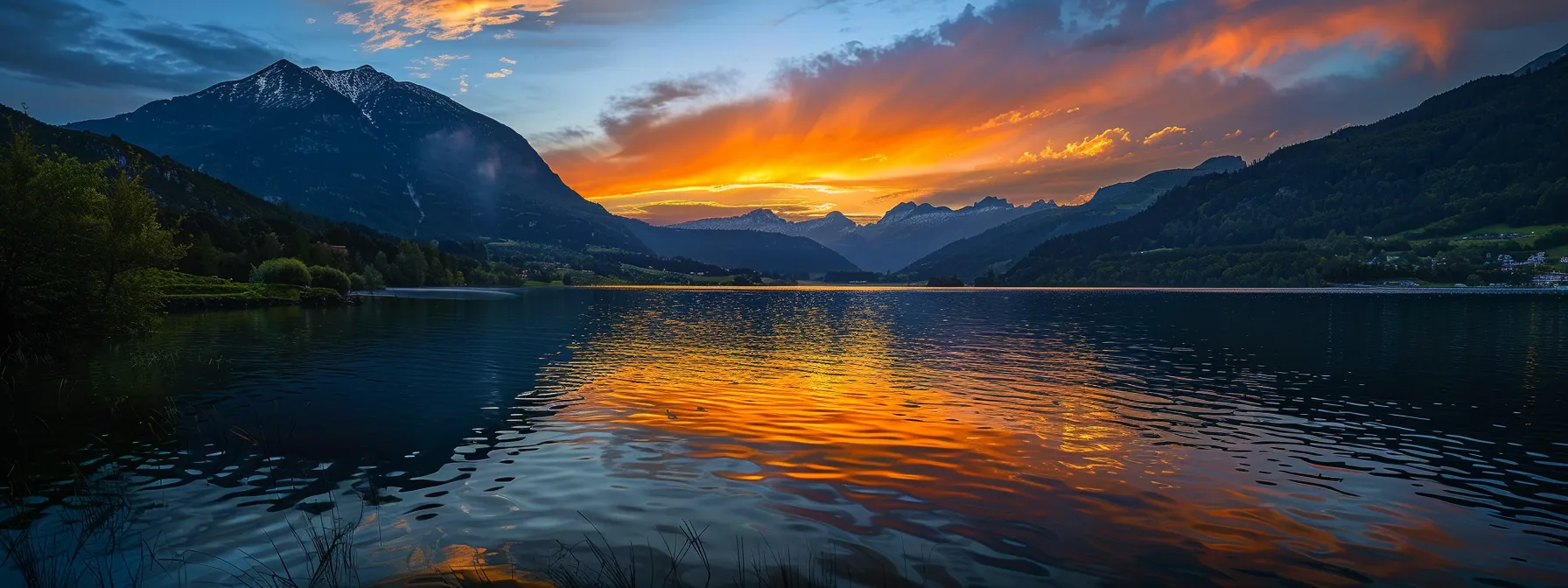 ein lebendiger sonnenuntergang über einem spiegelglatten see, der von majestätischen bergen umgeben ist, während die warmen farben des himmels das wasser in glühendes gold tauchen.